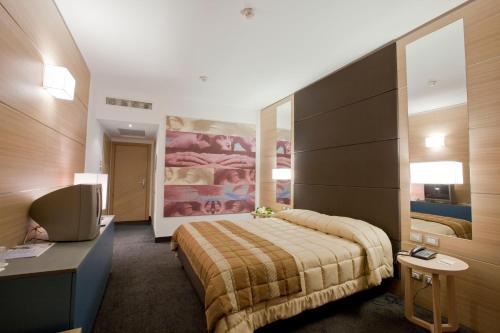 Un pat sau paturi într-o cameră la Centrum Palace Hotel & Resorts