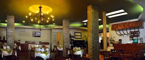 un comedor con mesas y una lámpara de araña en Crismar Experience By Xima Hotels, en Arequipa