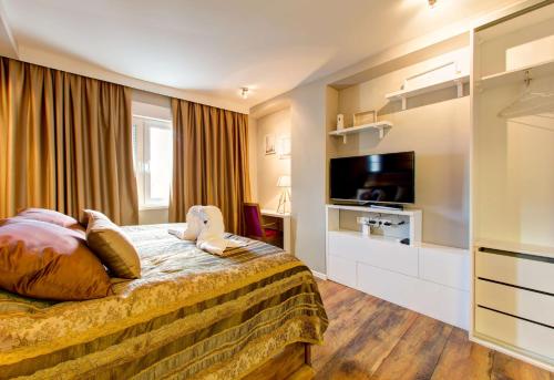 a hotel room with a bed and a flat screen tv at Luxury Studio Yasmine in Mostar