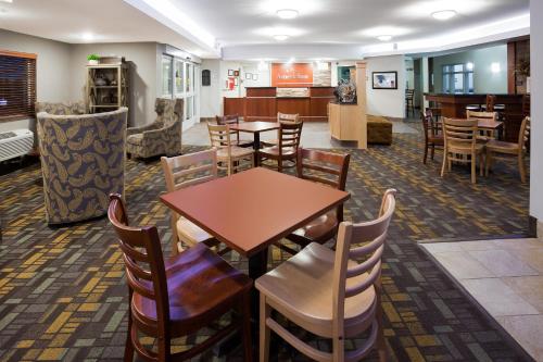 a dining room with tables and chairs in a waiting room at AmericInn by Wyndham Sibley in Sibley