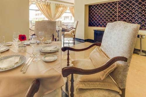 a dining room with a table with glasses and a chair at Barceló Aruba - All Inclusive in Palm-Eagle Beach