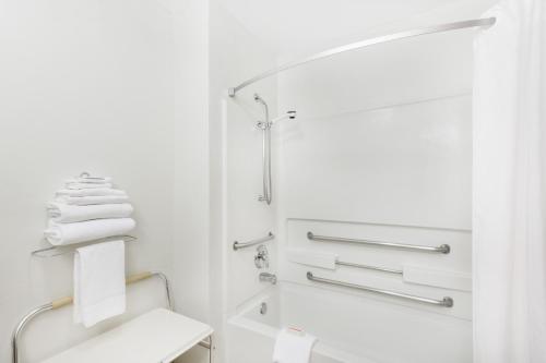 y baño blanco con aseo y ducha. en Super 8 by Wyndham Grants Pass, en Grants Pass