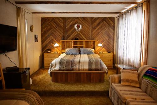 1 dormitorio con 1 cama y 1 sofá en Bluenose Bed & Breakfast en Snow Lake