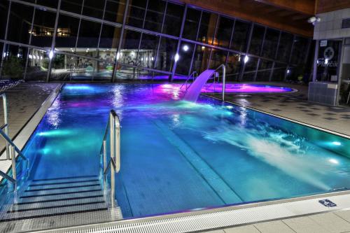 a swimming pool at night with a fountain at Hotel SOREA TRIGAN in Štrbské Pleso