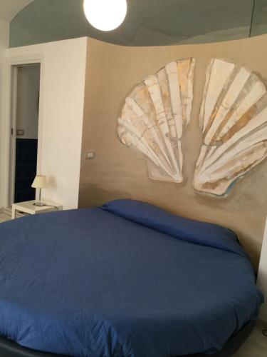 a bedroom with a blue bed and two shell decorations on the wall at My suite Sorrento in Sorrento