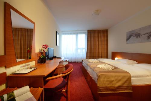 a hotel room with a desk and a bed at Hotel SOREA TRIGAN in Štrbské Pleso