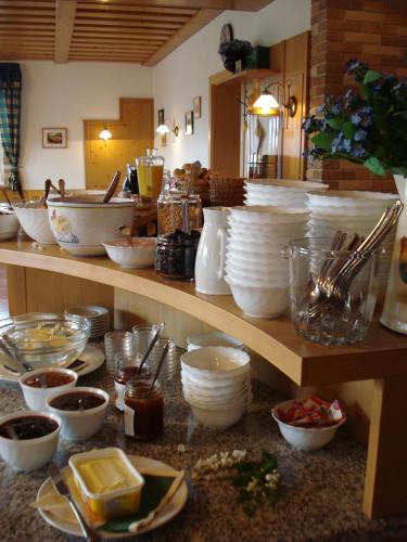 a counter with bowls and plates and other dishes on it at Pension Rudi - Weingut Kellner in Pulkau