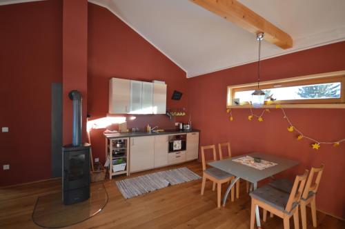 a kitchen with red walls and a table and a stove at Holzmichel in Friedrichroda