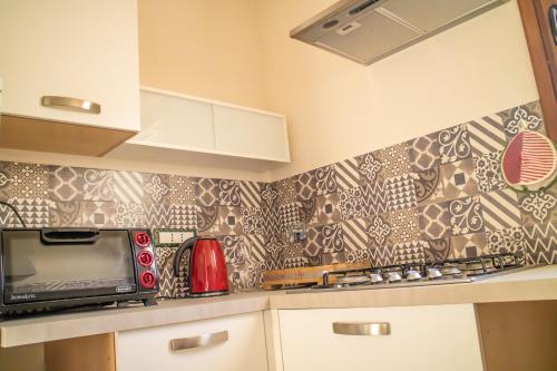 a kitchen with a microwave and a counter top at Il Marrondindo Bed & Breakfast in Galliano