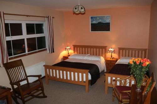 a bedroom with two beds and a table and chairs at An Portán Guest House in Dunquin