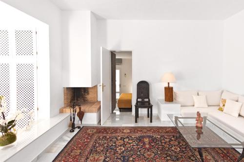 a living room with a white couch and a rug at Hotel Village in Cala Vadella