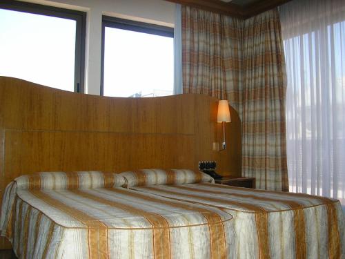 
a bedroom with a bed and a lamp at Hotel Aristol - Sagrada Familia in Barcelona
