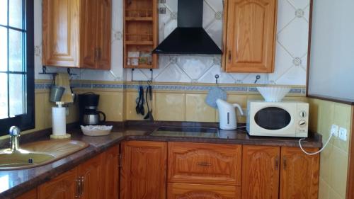 a kitchen with a microwave and a sink at Vivienda Vacacional La Roca in La Restinga
