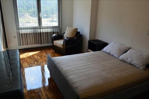 Un dormitorio con una cama y una silla y una ventana. en Apartment Luka, en Ohrid