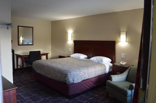 Habitación de hotel con cama y silla en Economy Inn, en Portland