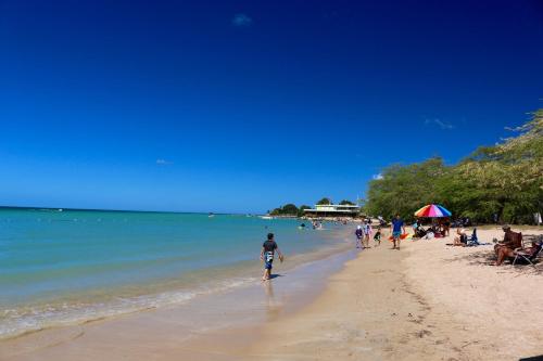 a group of people walking on the beach at Combate Beach Resort in Cabo Rojo