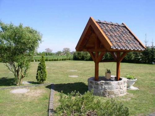 a wooden gazebo with a roof on a field at Ferienhaus Stolpe USE 1860 in Stolpe auf Usedom