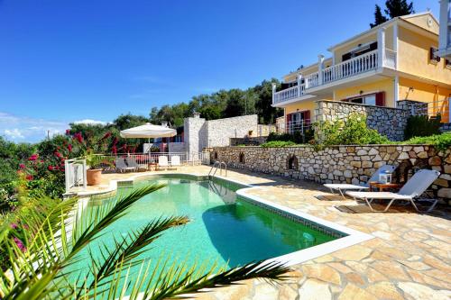 a swimming pool in front of a house at Villa Avgerini Paxos in Gaios
