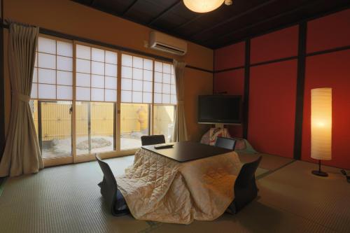 a room with a table and a large window at Daisenji Lodge Ing 墨 地下鉄鞍馬口駅から徒歩1分 in Kyoto