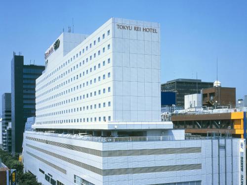 a tall white building with the virgin america hotel at Shin Osaka Esaka Tokyu REI Hotel in Suita