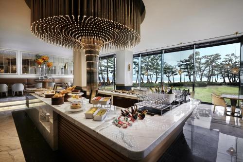 a buffet line in a restaurant with a large chandelier at Paradise Hotel Busan in Busan