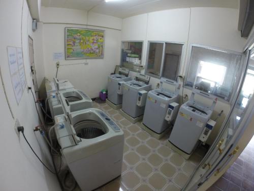 una habitación con una fila de lavadoras. en Earth Mansion Sai 5 en Sam Phran
