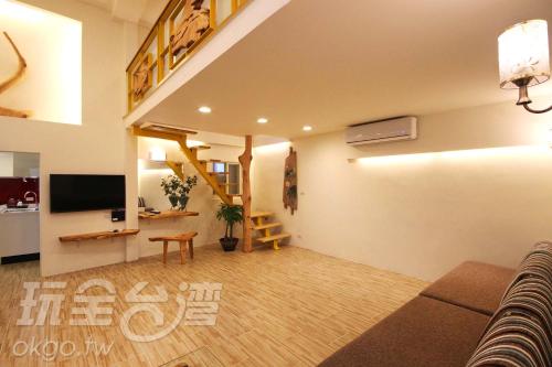 una sala de estar con un sofá y un televisor en Chien Ching B&B, en Jiufen