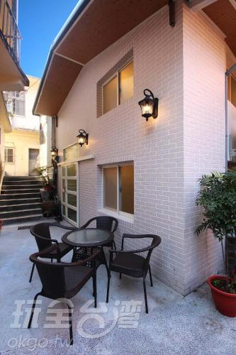 un patio con tavolo e sedie di fronte a un edificio di Chien Ching B&B a Jiufen