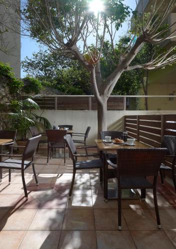 a table and chairs and a tree on a patio at Irida Hotel in Chania Town