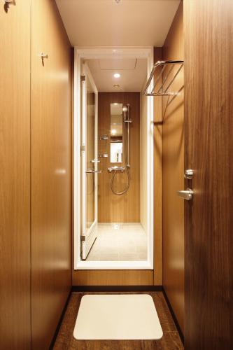 a bathroom with a shower with a mirror at MyCUBE by MYSTAYS Asakusa Kuramae in Tokyo