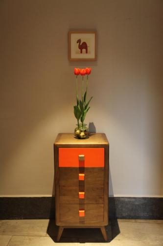 a dresser with a vase of flowers on top of it at Ron Inn Xingping Hepan Xiaozhu in Yangshuo