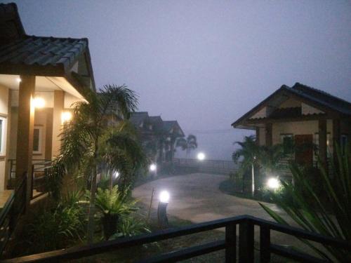 Una vista de una calle de noche con casas. en Ouidee Resort, en Na Noi