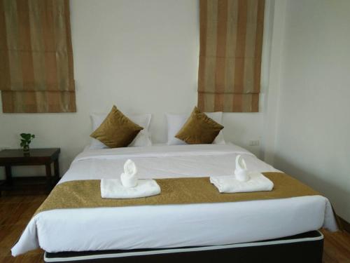 ein Schlafzimmer mit einem Bett, auf dem zwei Handtücher liegen in der Unterkunft Ouidee Resort in Na Noi