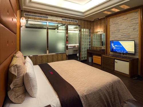 1 dormitorio con 1 cama y TV de pantalla plana en Lai Yin Motel en Longtan