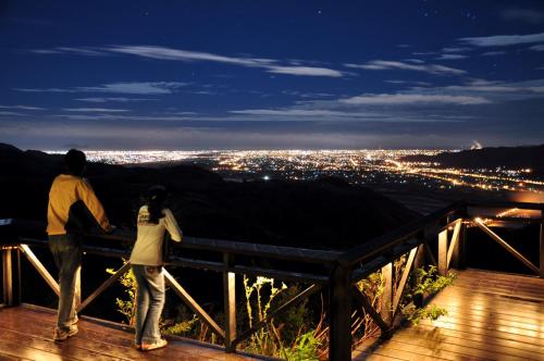 a man and woman standing on a deck looking at a city at Ying Yue Villa in Datong