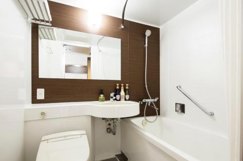 uma casa de banho com um lavatório, um WC e um espelho. em HOTEL MYSTAYS Ueno East em Tóquio