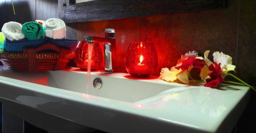 un lavabo con gafas rojas y flores. en Cinnamon Apartment Panadura, en Panadura