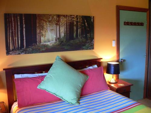 um quarto com uma cama com almofadas rosa e verde em The Haven - Island Beach em Island Beach