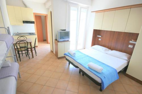 リミニにあるResidence Algarveのベッドルーム1室(ベッド1台付)、キッチン(テレビ付)