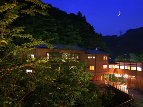 a building at night with a moon in the sky at Yamayuri no Yado in Hanamaki
