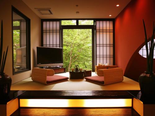 a living room with a large window and a television at Yamayuri no Yado in Hanamaki