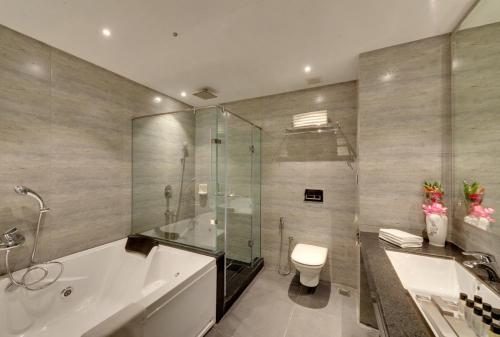 a bathroom with a tub and a toilet and a shower at Hotel Combermere in Shimla