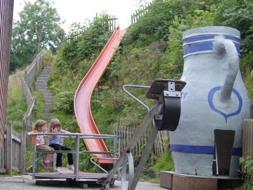 two little girls sitting on a roller coaster at Apartment Hulfteggpass in Mühlrüti