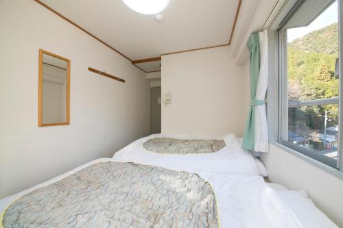 a small bedroom with a bed and a window at Sansuikan Kawayu Matsuya in Hongu