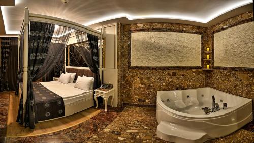 a bathroom with a tub and a bed in a room at Samir Deluxe Hotel in Istanbul
