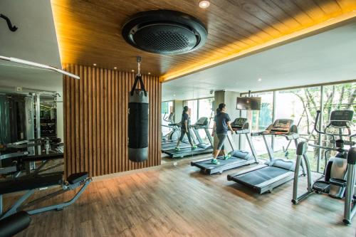 a gym with several treadmills and people in the gym at Fusion Suites Phuket Patong in Patong Beach