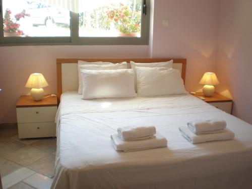 a bedroom with a white bed with two towels on it at Marvelous house by the sea in Vouliagmeni Lake