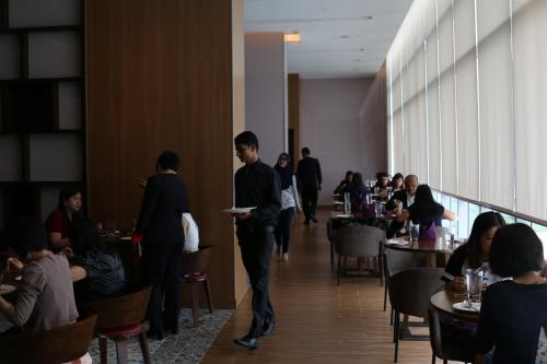 a group of people walking down a hallway in a restaurant at Mercure Kuala Lumpur Shaw Parade in Kuala Lumpur