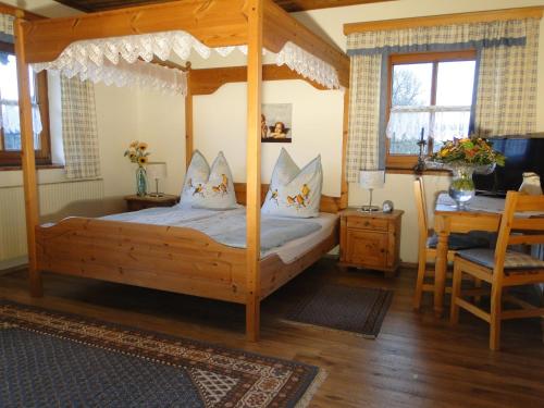 sypialnia z drewnianym łóżkiem z baldachimem i biurkiem w obiekcie Gästehaus Steinerhof w mieście Salzburg
