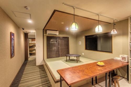 a dining room with a table and a couch at Guest House Nakaima in Fukuoka